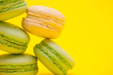 Makro tatlı Fransızca macaroons sarı arka plan üzerinde