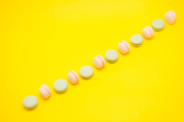 Fransızca macaroons sarı arka plan üzerinde çeşitli satır