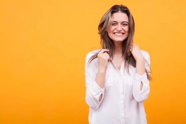 Glad ung flicka med stort leende över gul bakgrund — Stockfoto