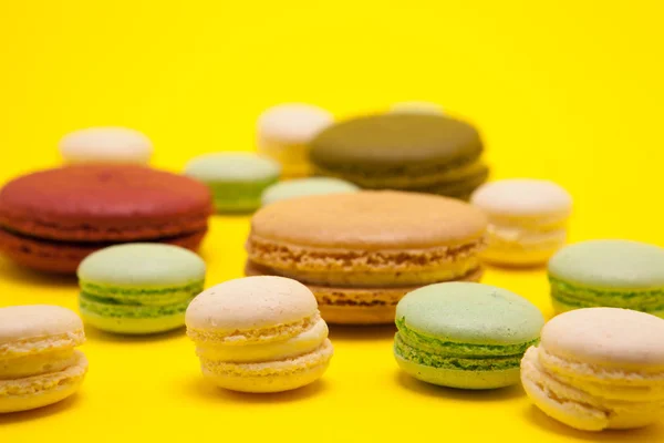 Kleine bitterkoekjes vanille smaak naast verschillende smaken op gele achtergrond — Stockfoto