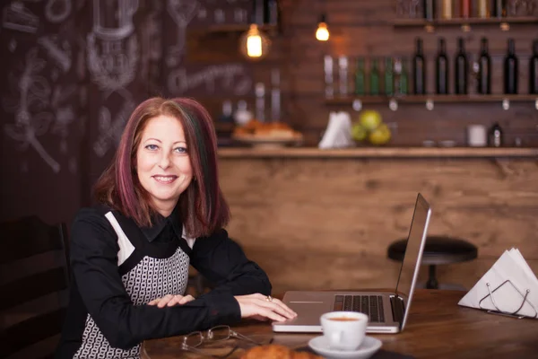 Glimlachende zakenvrouw met een laptop in lettertype van haar — Stockfoto