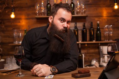 Yakışıklı genç barmen sakalını ile oynamak.