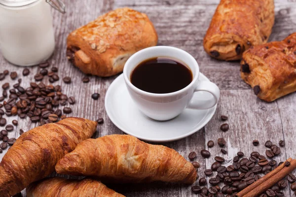 Frühstück mit frischen Coissants mit Kaffee und Milch auf rustikalem Holztisch — Stockfoto