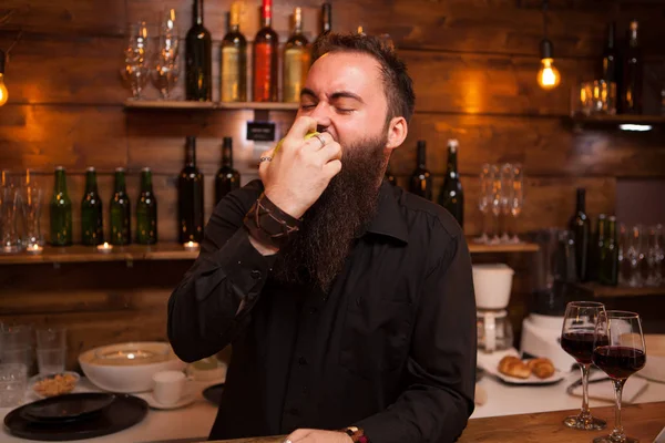 Bartende comiendo deliciosa manzana verde detrás del mostrador de la barra . —  Fotos de Stock