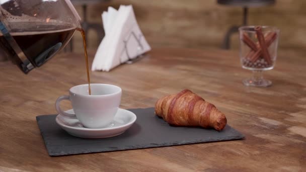 Nahaufnahme von warmem Kaffee, der aus einem vollen Becher gegossen wird — Stockvideo