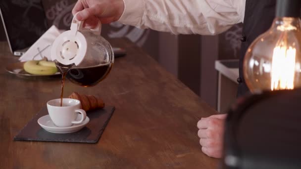 Прохолодний кінематограф руки чоловіка наливає каву з глечика на барну стійку — стокове відео