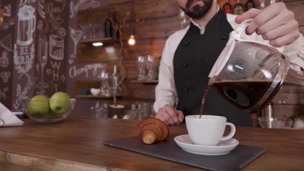 Barista muž cinemagraph, zatímco drží džbánu a nalít kávu v prázdný pohár — Stock video