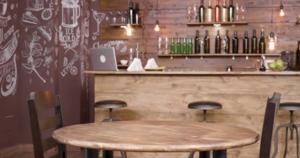 Paralaje de una mesa vacía y dos sillas frente a un bar — Vídeo de stock
