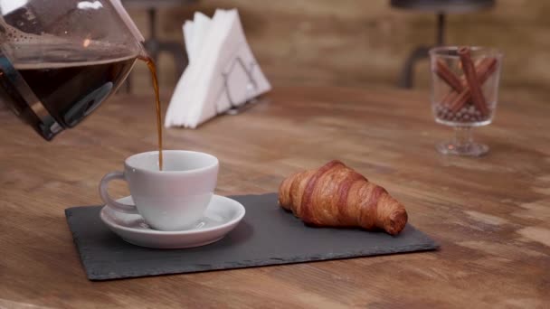 Primo piano di caffè caldo versato da una tazza piena appena preparata — Video Stock