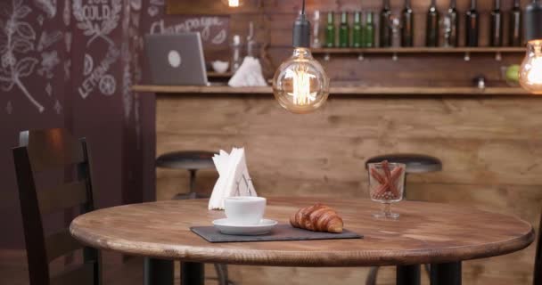 Egy csésze kávé és egy croissant-t, egy sötét tálcán minimalista összetétele — Stock videók