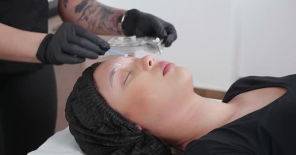 Femme appliquant une crème anesthésiante sur les sourcils avant le retrait du tatouage — Video