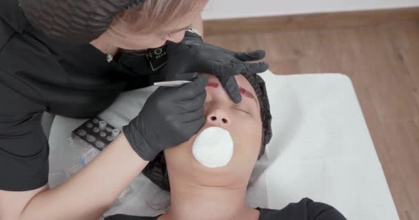 Cosmetologist placed a cotton cloth on her customers mouth while working — Stock Video