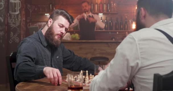 Two stylish hipster men playing a chess game in a bar — Stock Video