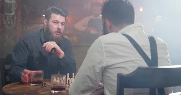 Mejores amigos se conocieron en un bar ahumado para una partida de ajedrez durante un descanso — Vídeos de Stock