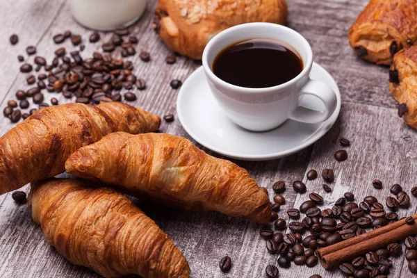 Kaffee und Croissant zum Frühstück auf rustikalem Holztisch — Stockfoto