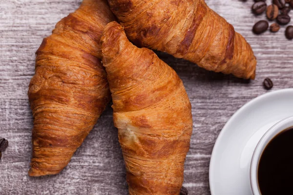 Delicious croissants on vintage wooden table — Stock Photo, Image