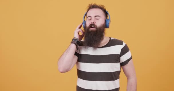 Joven hipster barbudo escuchando música y disfrutándola — Vídeos de Stock