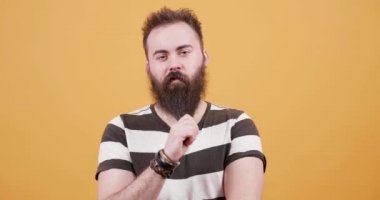 Sarı arka plan önünde bir t-shirt giymiş genç ve güzel sakallı adam