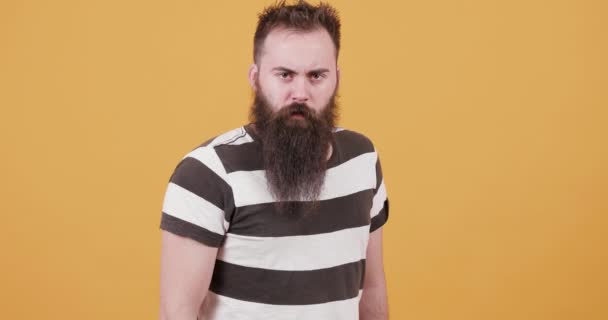 Uomo barbuto sembra serio poi sorridente — Video Stock