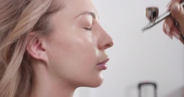 Using airbrush makeup machine to make the face look clean and beautiful — Stock Video