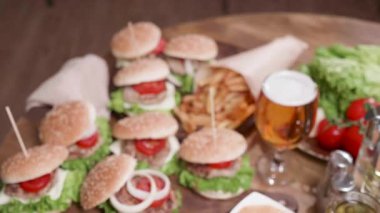 Bir pleateau Burger bir ahşap yüzeyde ortaya yukarıda kamera hareketi