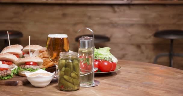 Slide shot de hamburguesas sobre una mesa de madera en un pub vintage — Vídeos de Stock