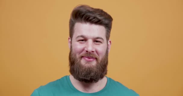 Νέος γένια hipster γελώντας και δείχνοντας ένα αστείο πρόσωπο — Αρχείο Βίντεο