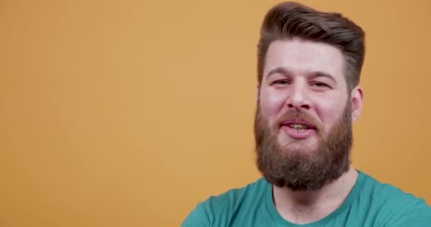 Aantrekkelijke man met lange baard luistert naar een grap en lacht — Stockvideo