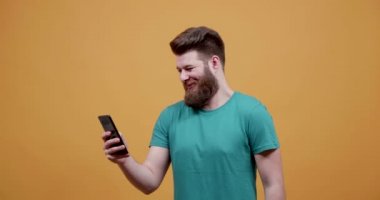 Komik Resimler ve videolar, sarı bir arka plan önünde onun telefon bakarak adam