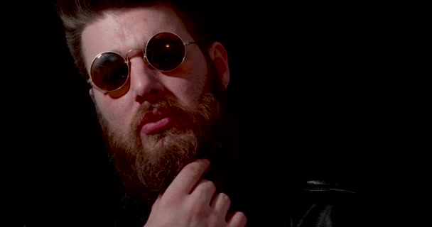 Licht lekken op het gezicht van een gevaarlijk uitziende man die in het bezit van zijn baard — Stockvideo