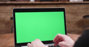 Ekranda yeşil ekran ile modern bir dizüstü bilgisayarda yazarak erkek el atış statik