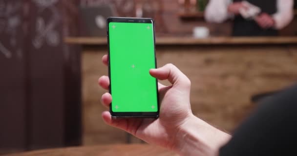 Человек прокручивает на телефоне зеленый экран — стоковое видео