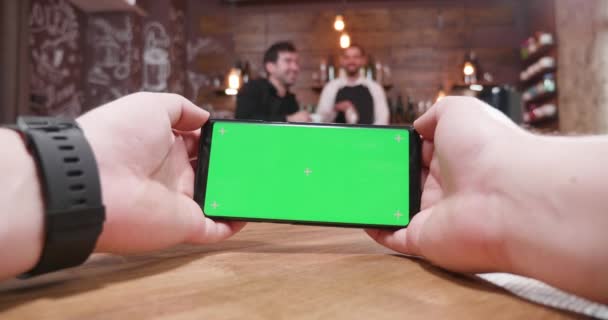 Видеозапись мужских рук, играющих в видеоигру за столом в винтажном кафе — стоковое видео