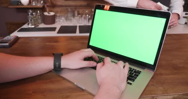 Mann tippt schnell auf Laptop mit grünem Bildschirm — Stockvideo