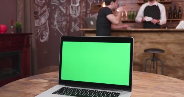 Laptop with green scree on a table — Stock Video