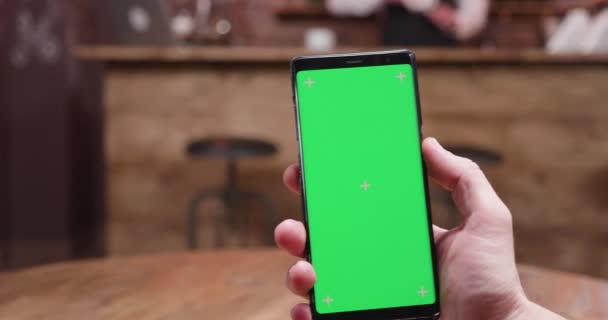 Snel bewegende parallax schot van telefoon met groen scherm op het display — Stockvideo