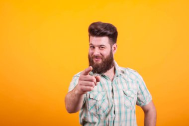 Kameraya sarı arka plan üzerinde işaret focu elinde olan yakışıklı adam