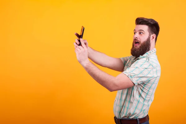 Hipster γενειοφόρος άνδρας κάνει μια selfie πάνω από το κίτρινο φόντο — Φωτογραφία Αρχείου