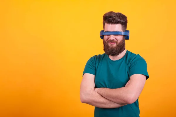 Attraktiver bärtiger Mann, der mit Headset vor gelbem Hintergrund herumalbert — Stockfoto