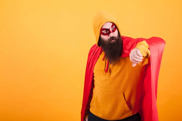 Hipster mit langem Bart im Superheldenkostüm blickt über gelben Hintergrund hinweg — Stockfoto