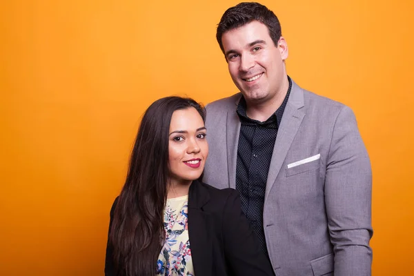 Alegre jovem casal sorrindo sobre fundo amarelo — Fotografia de Stock