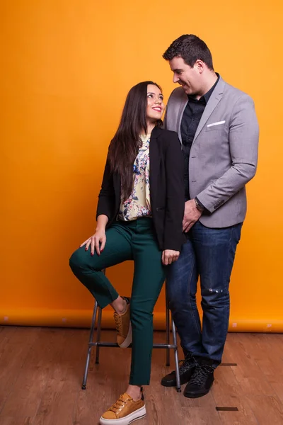 Pareja joven casualmente vestida sonriendo sobre fondo amarillo —  Fotos de Stock