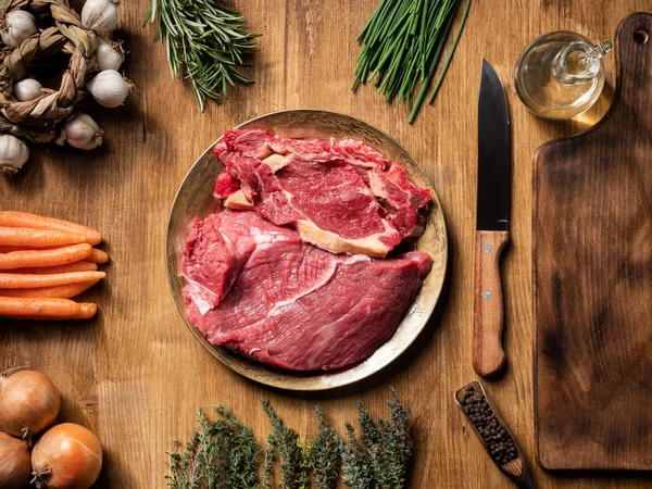 Nature morte de viande crue avec des légumes sur une table en bois — Photo