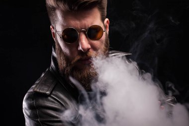 Deri ceket siyah arka plan üzerinde kamera bakarak cool sakallı adam