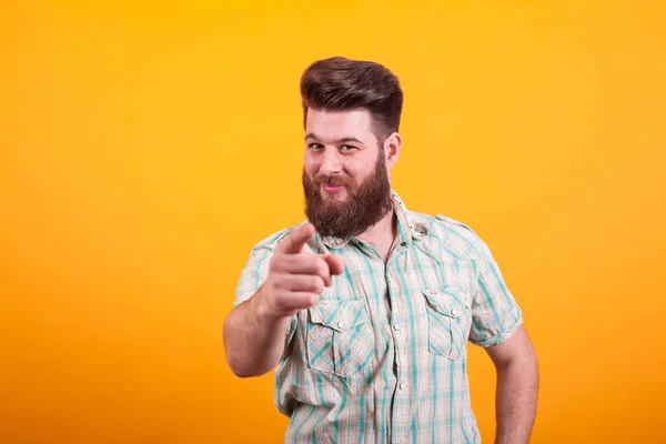 Portrait d'un homme barbu pointant la caméra sur fond jaune — Photo