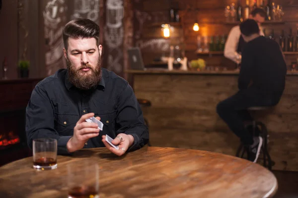 Guapo barbudo perdido en sus pensamientos junto a un vaso de whisky —  Fotos de Stock