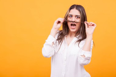 Güzel kız Beyaz gömlekli saçı sarı arka plan üzerinde oynama