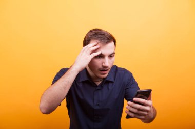 Genç adam Sarı zemin üzerine yaptığı telefon şok bakan