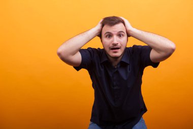 Heyecanlı yakışıklı mavi gömlek sarı arka plan üzerinde şok