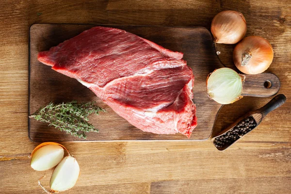 Poivrons vue du dessus à côté d'un gros morceau de viande rouge sur une planche à découper vintage — Photo